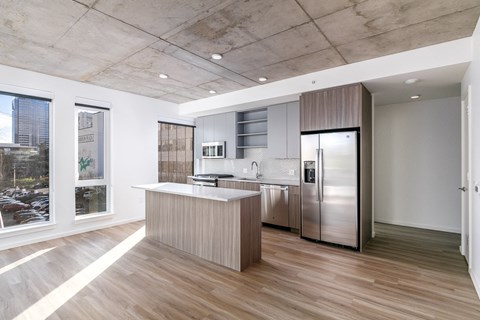 a kitchen with a island and a stainless steel refrigerator