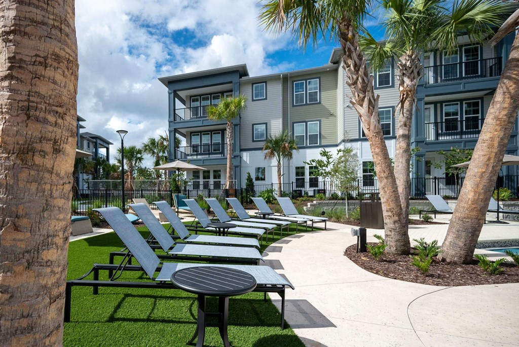 a row of lounge chairs in front of an apartment building