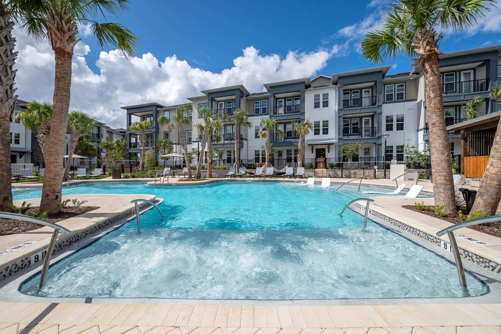 a large swimming pool with an apartment building in the background