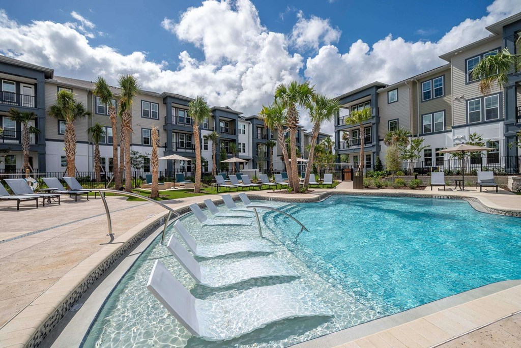 a swimming pool with an apartment building in the background