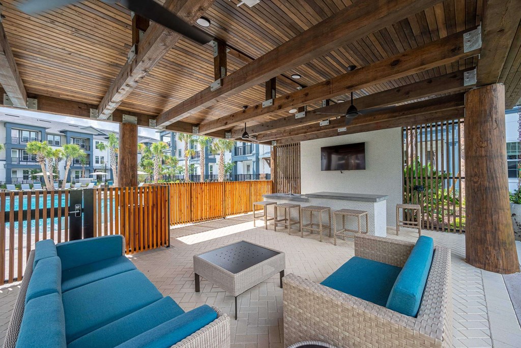 a patio with couches and a table and a tv