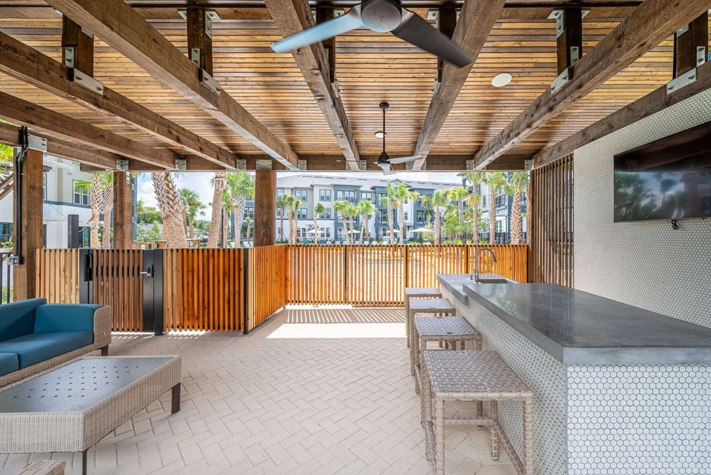 a covered patio with a bar and a television