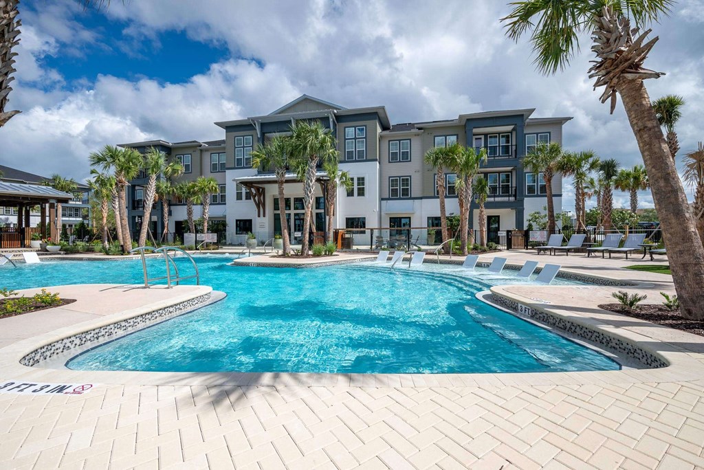 a large swimming pool with an apartment building in the background