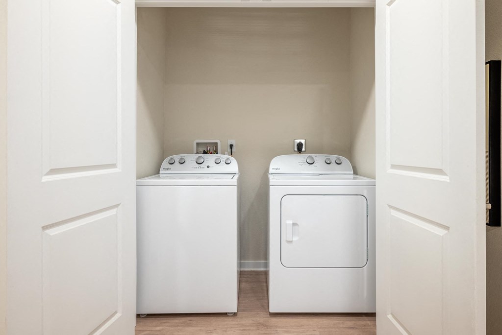 two washers and dryers in a laundry room with white doors