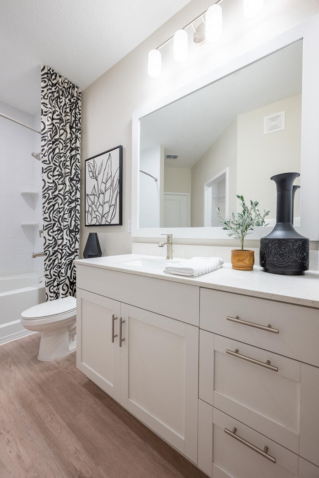 a bathroom with a large mirror and a toilet and a sink
