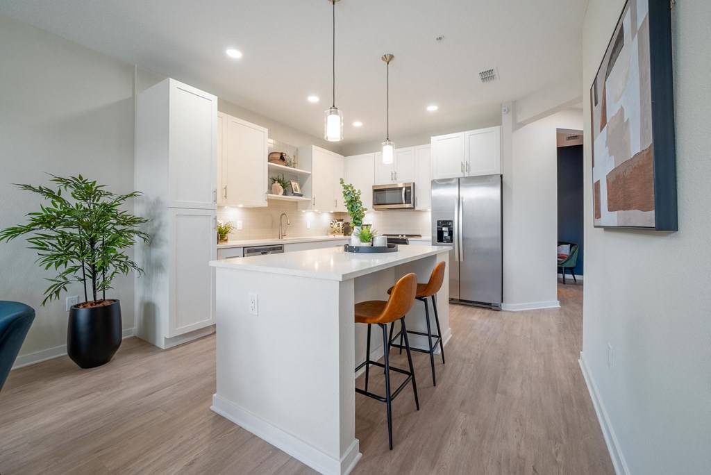 an open kitchen with a large island with three stools