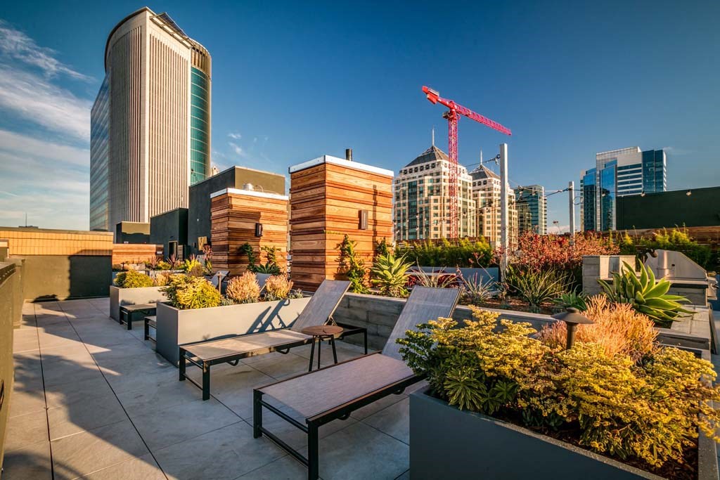 a rooftop terrace with benches and a city skyline