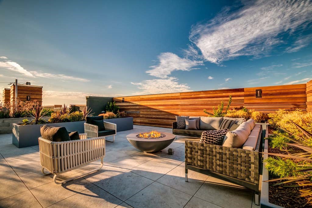 a roof terrace with couches and a fire pit