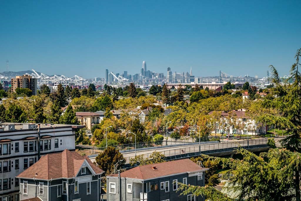 a view of the city skyline from a neighborhood with houses and trees