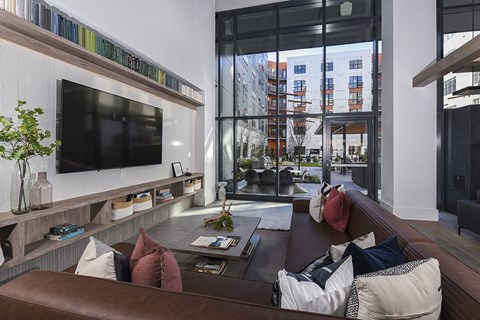 a living room with a leather couch and a television