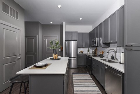 a kitchen with stainless steel appliances and gray cabinets