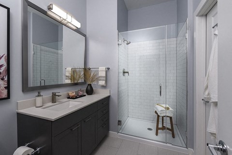 a bathroom with a shower and a sink and a mirror