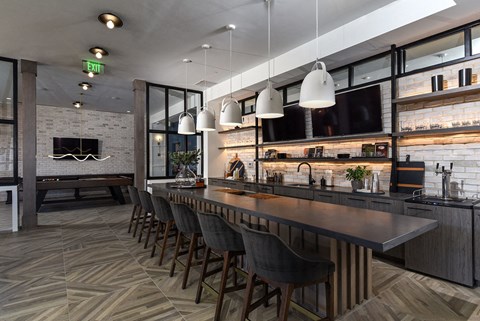 a long bar in a restaurant with chairs and a tv