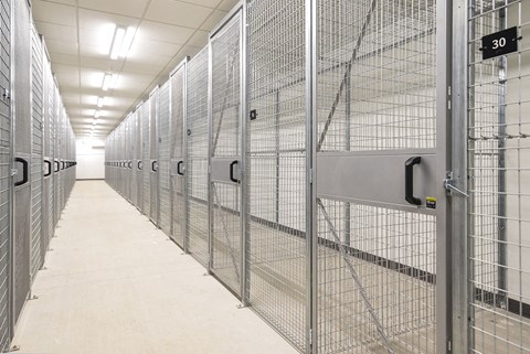 a row of prison cells with metal doors and walls