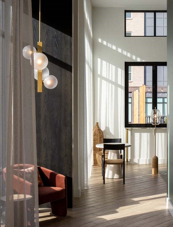 a living room with a chair and a desk and a window