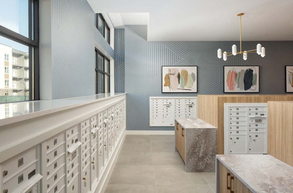 a large room with a long counter with white drawers and cabinets and a window