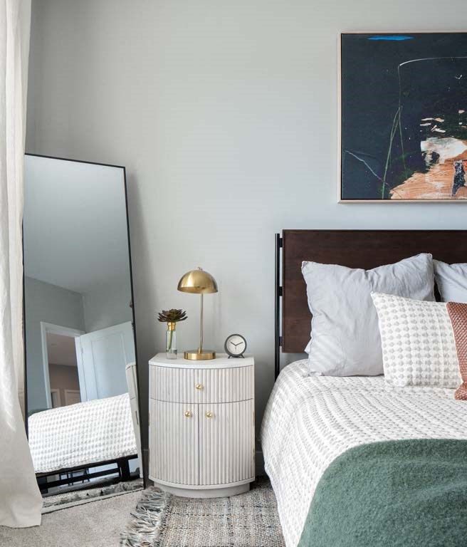 a bedroom with a bed and a large mirror