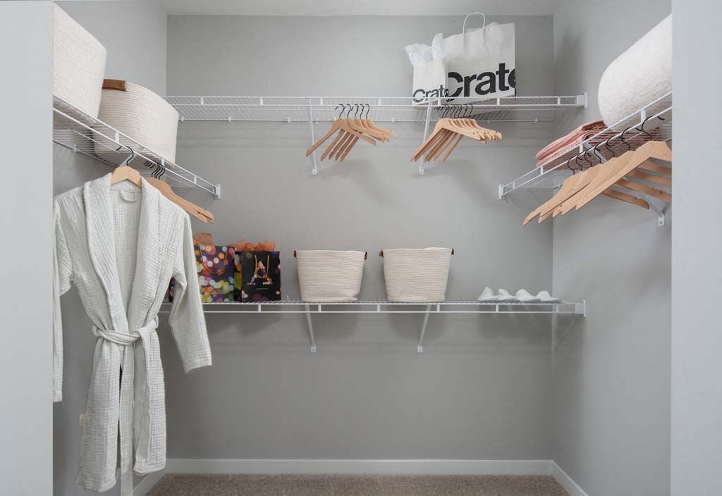 a walk in closet with drying racks and towels