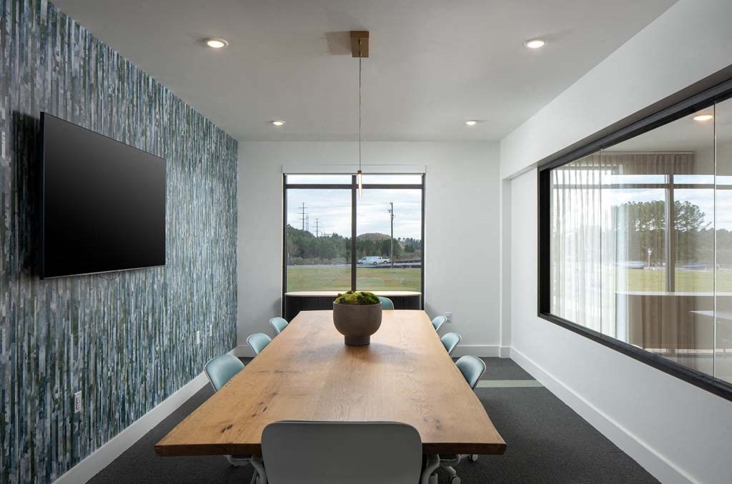 a conference room with a wooden table and chairs and a tv