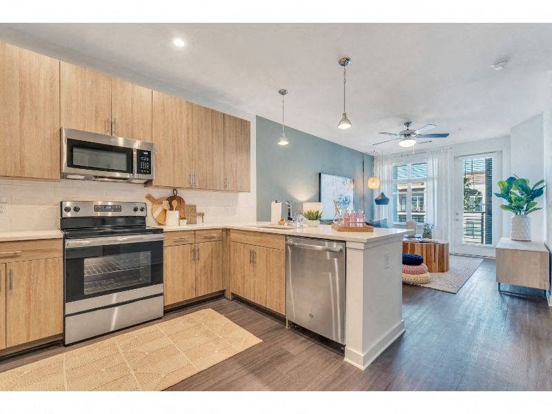 a large kitchen with stainless steel appliances and wooden cabinets