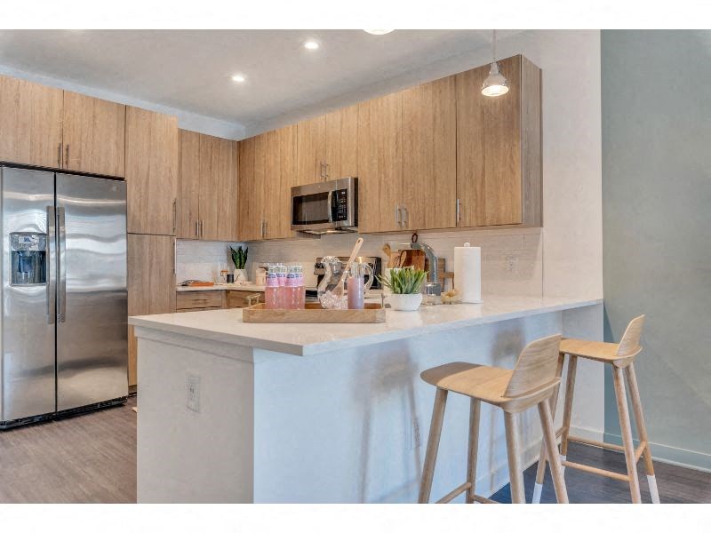 a kitchen with two bar stools and a refrigerator
