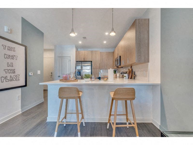 a kitchen with two stools in front of a counter top