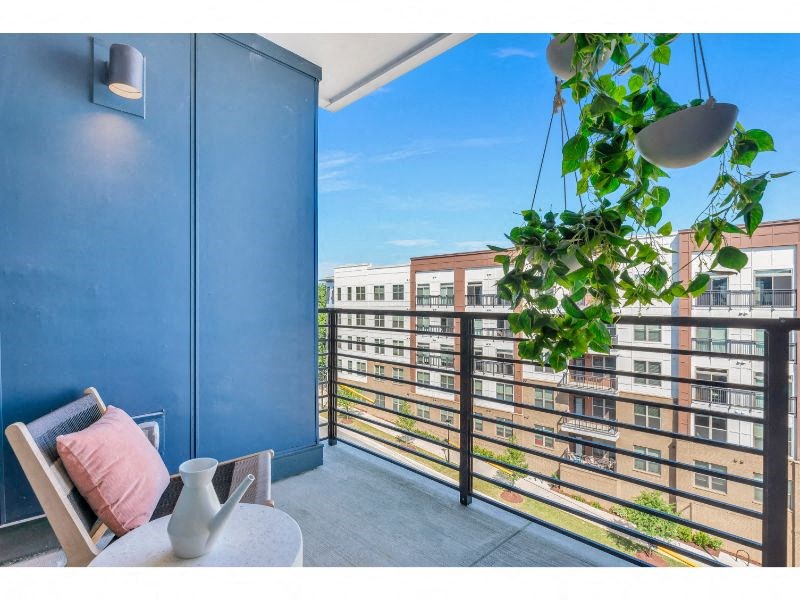 a balcony with a blue wall and a view of a city