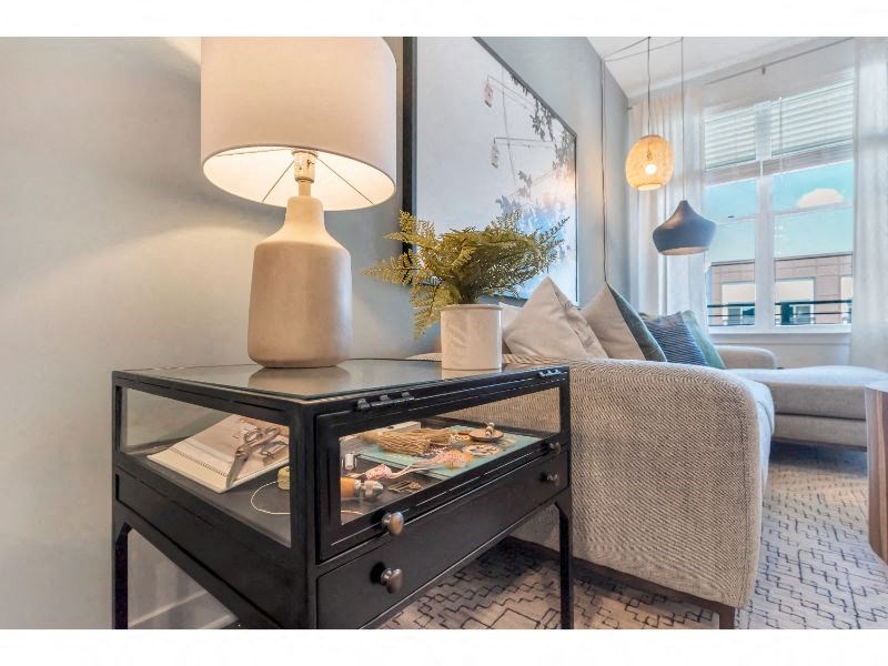 a living room with a couch and a table with a lamp