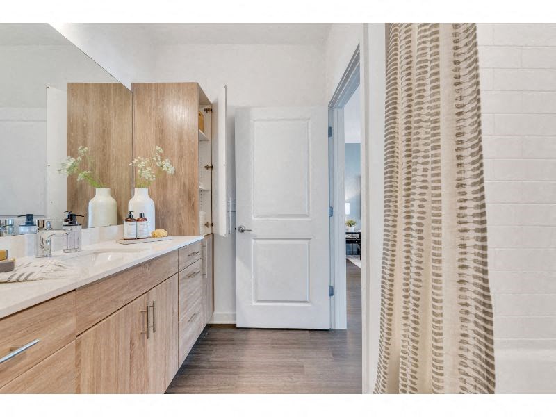 a bathroom with wooden cabinets and a white door