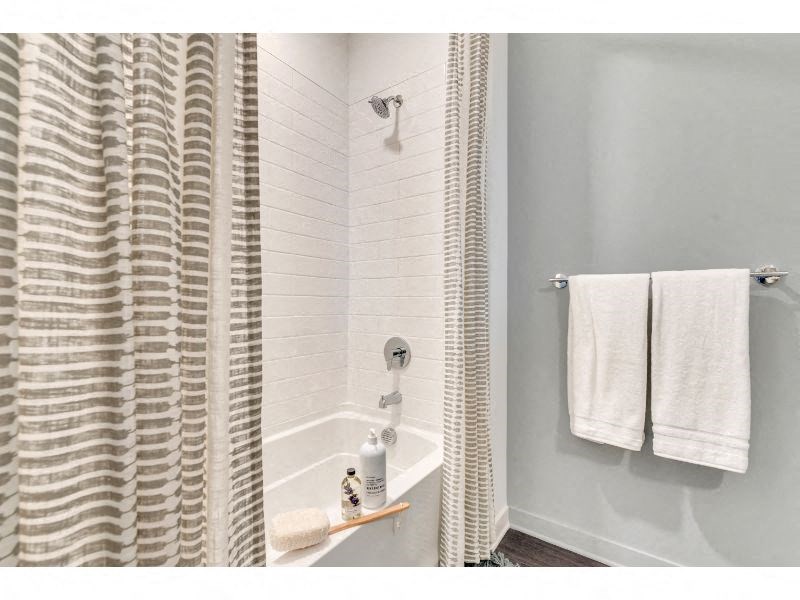 a bathroom with two white towels and a shower curtain