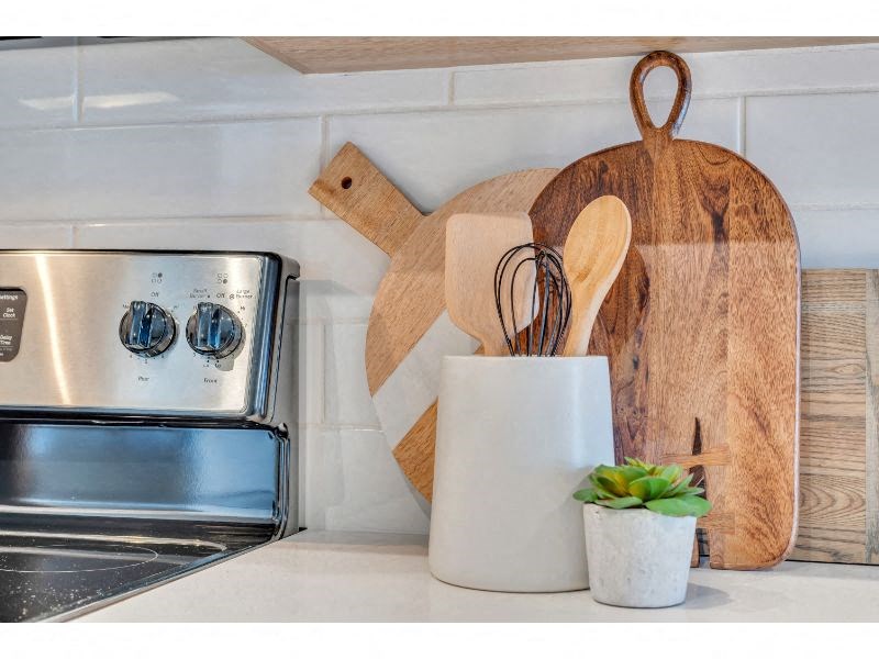 a kitchen with a stove and some wooden utensils on the counter