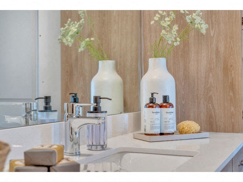a bathroom sink with two white vases with flowers on it