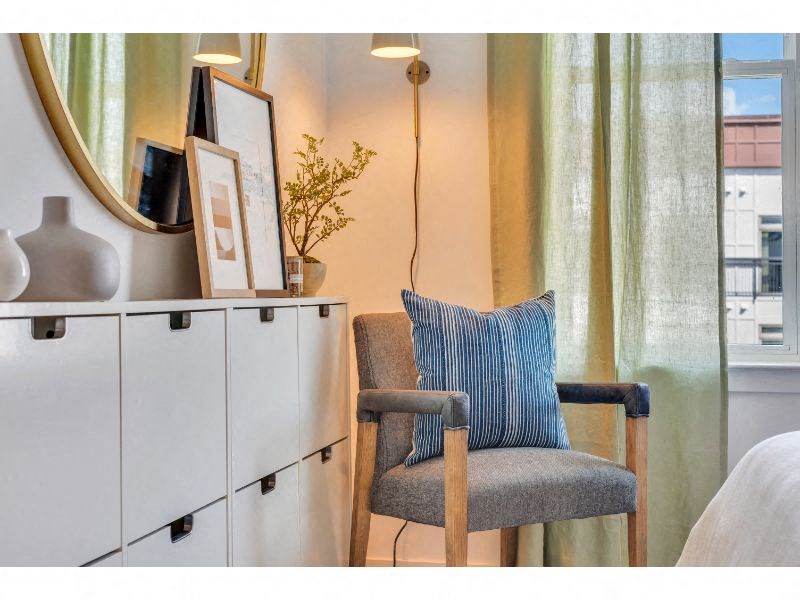 a chair with a blue pillow sitting next to a window