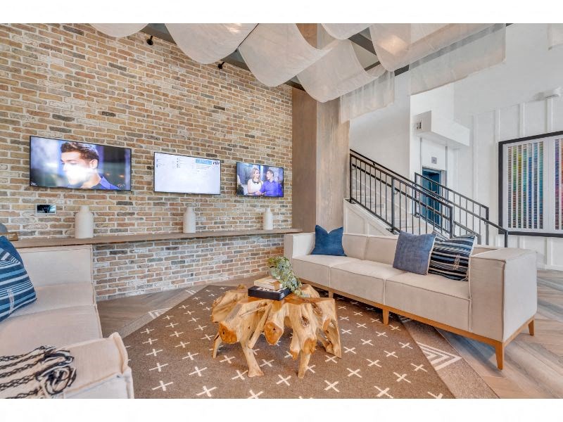 a living room with a brick wall and a couch and a table