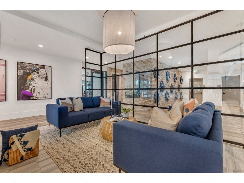a living room with blue couches and a large glass window