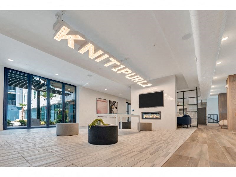 a large lobby with a tv and a glass door