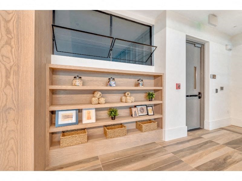 a hallway with shelves and a glass door