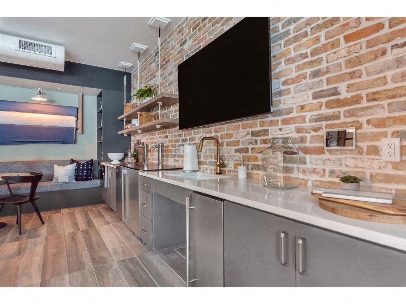 a kitchen with stainless steel counter tops and a brick wall
