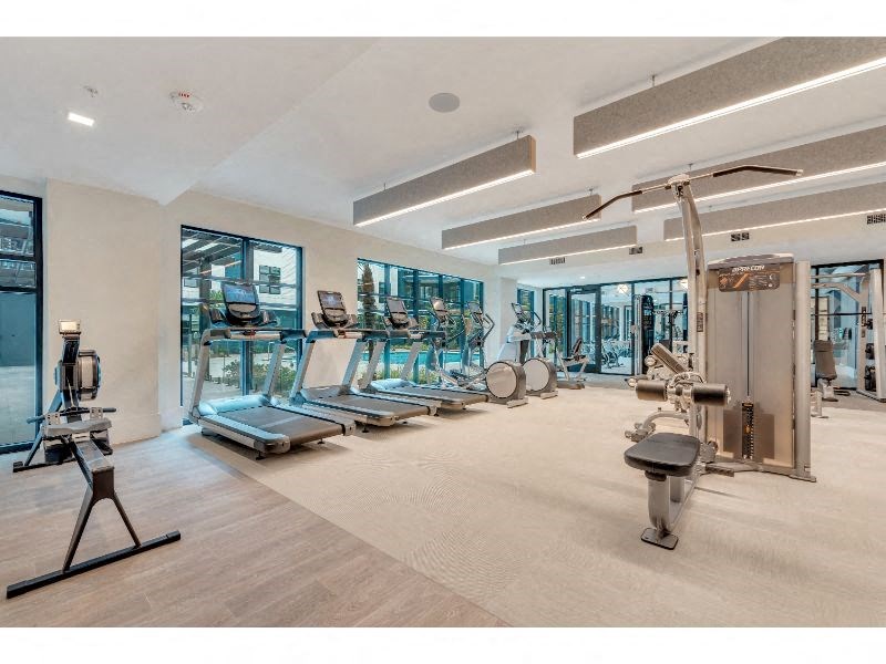 a gym with cardio machines and weights on the floor