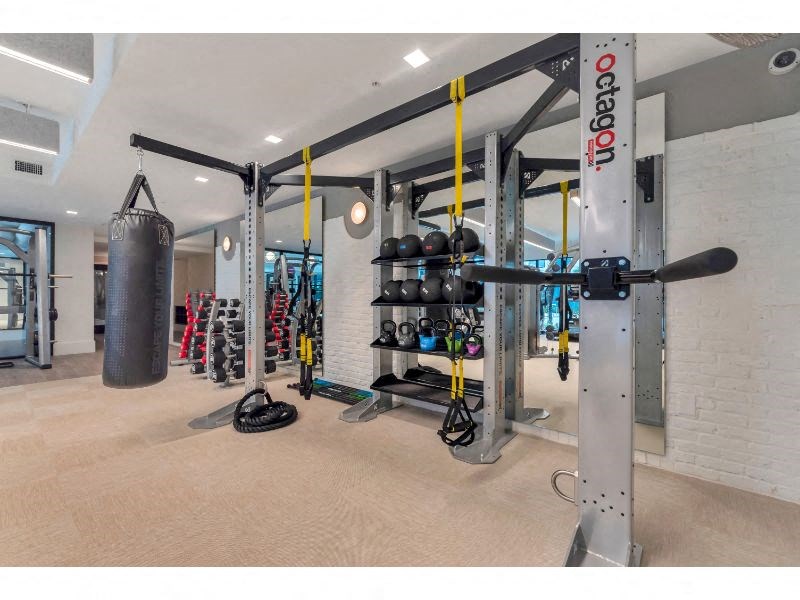 a gym with weights and a punching bag on the floor