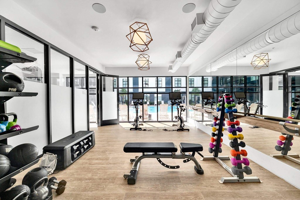 a gym with a pool and a lot of exercise equipment