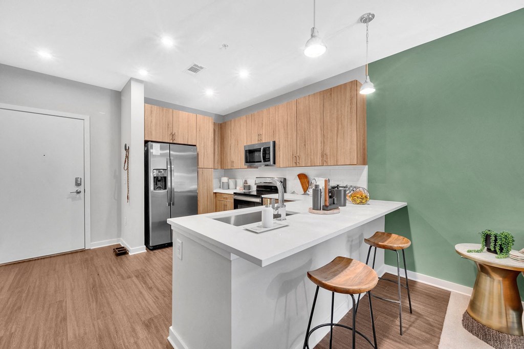 a kitchen with a white counter top and a stainless steel refrigerator