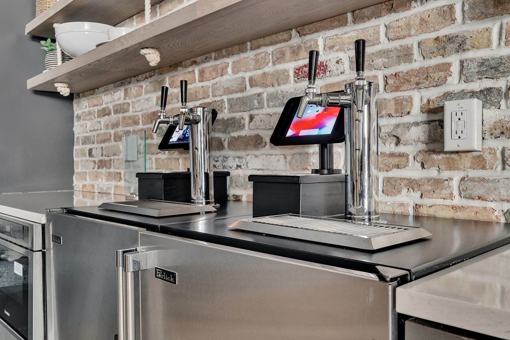 a kitchen with a stainless steel counter top and a brick wall