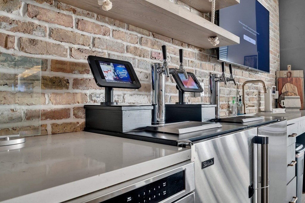 a kitchen with appliances and a brick wall