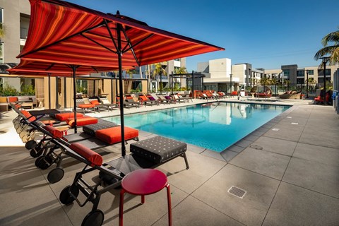 a swimming pool at a hotel with chairs and umbrellas