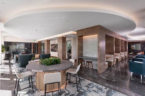 the lobby of a hotel with tables and chairs