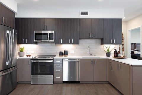 a modern kitchen with stainless steel appliances and dark wood cabinets