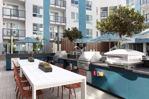a patio with a white table and chairs and a barbecue grill