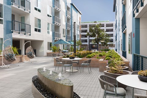 a courtyard with tables and chairs in an apartment building