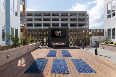 a patio with a fireplace and a wooden deck